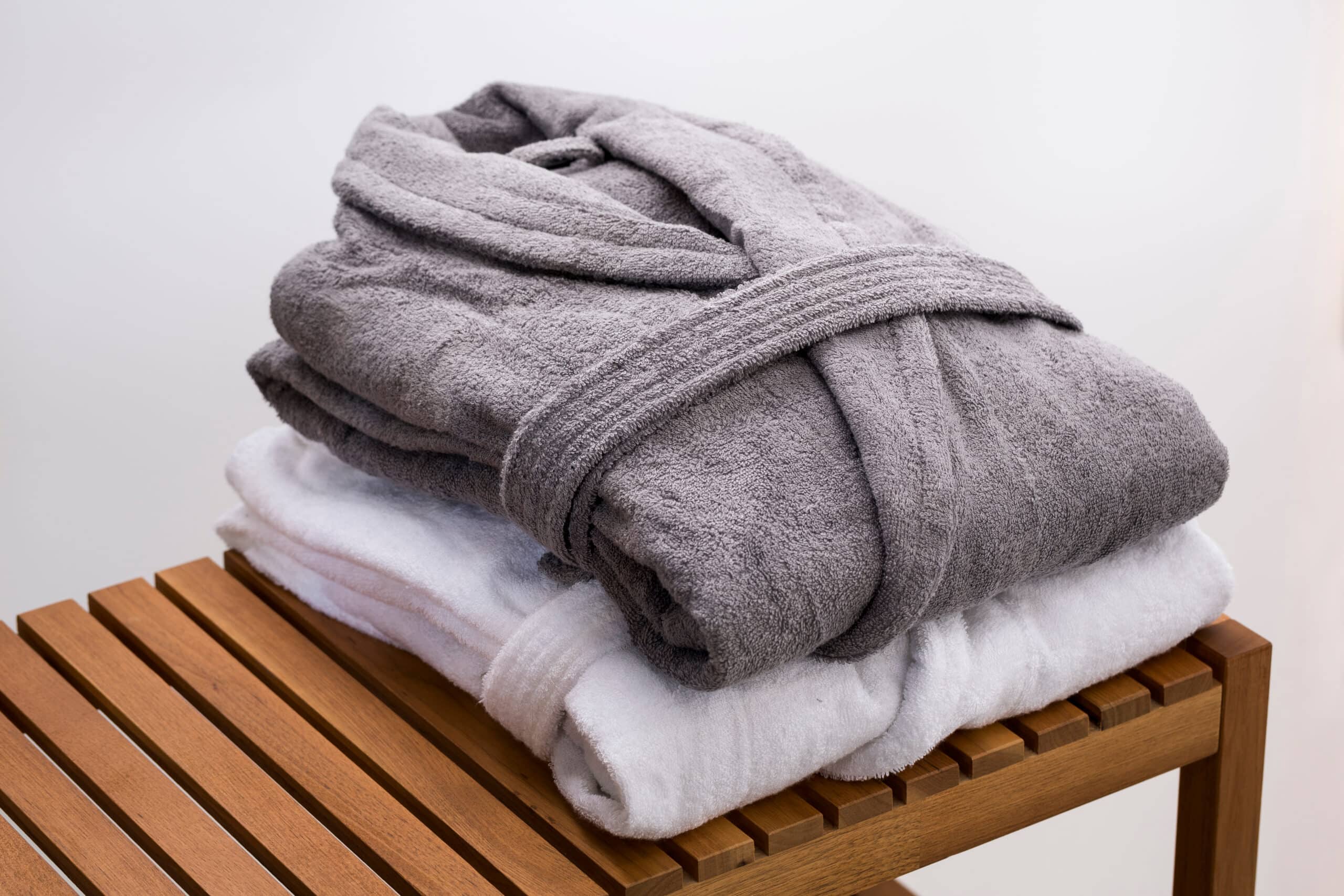 Grey,And,White,Bath,Robes,On,Wooden,Bench